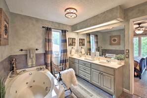 A bathroom with a large bathtub, double sinks, and a walk-in shower. There are towels hanging on the wall and a mirror above the sink. - 3 Mi to Lake Desoto: Home w/ Furnished Deck! (Hot Springs Village)