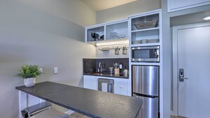 A modern kitchen with a built-in oven, microwave, and stainless steel refrigerator. There is a countertop with a sink and a potted plant. - San Marcos Apartment w/ Off-street Parking! (San Marcos)