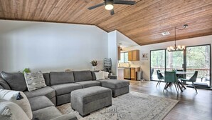 A modern living room with a sectional sofa, ottoman, and a dining area with a table and chairs. - ~ 8 Mi to State Park & Trails: Pine Mountain Home (Pine)