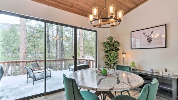 A dining area with a round table, green upholstered chairs, a marble top, and a chandelier. - ~ 8 Mi to State Park & Trails: Pine Mountain Home (Pine)