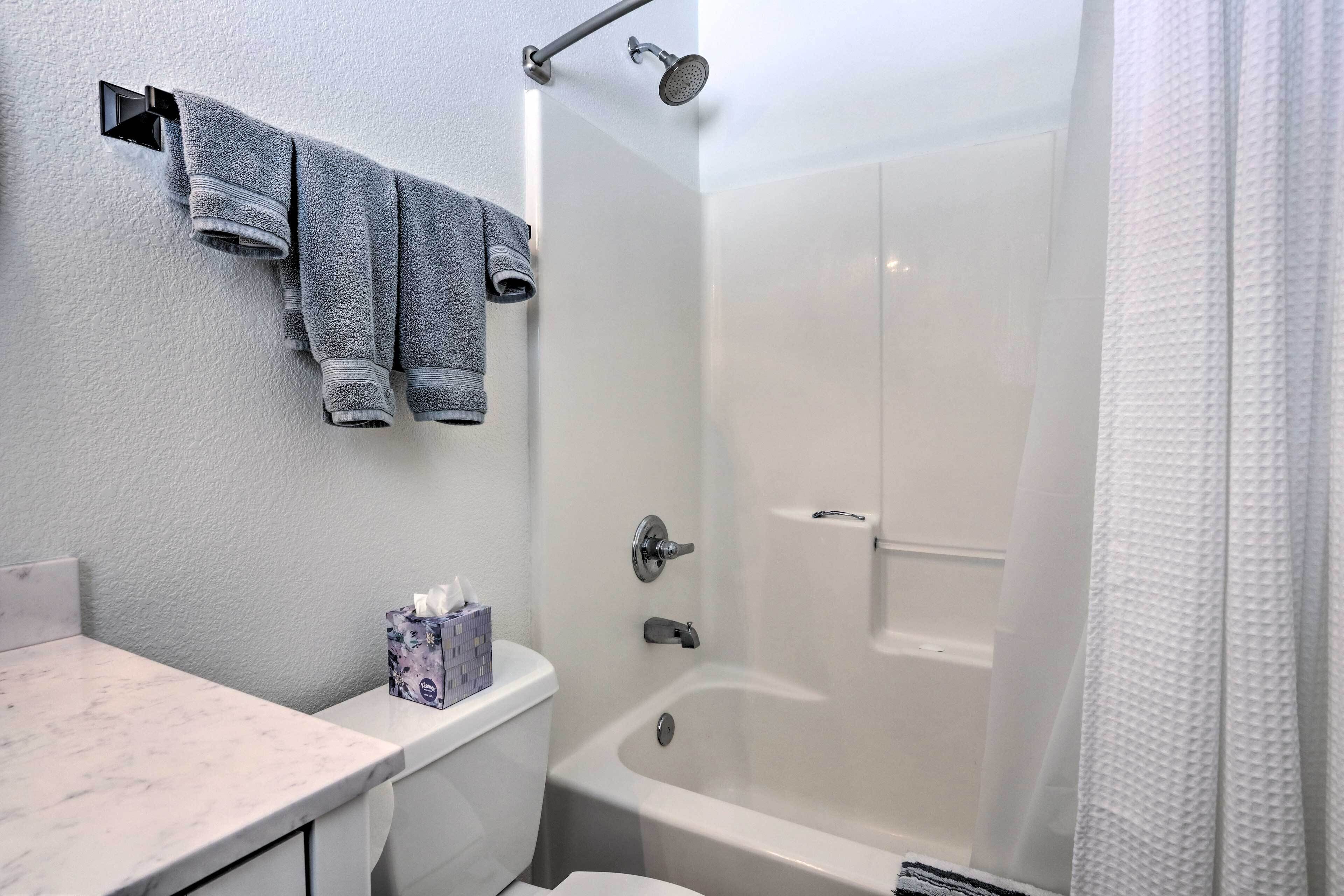 Un baño con inodoro, lavamanos, bañera y ducha.