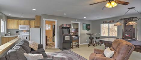A spacious living area with a dark gray sofa, a brown armchair, and a patterned rug.