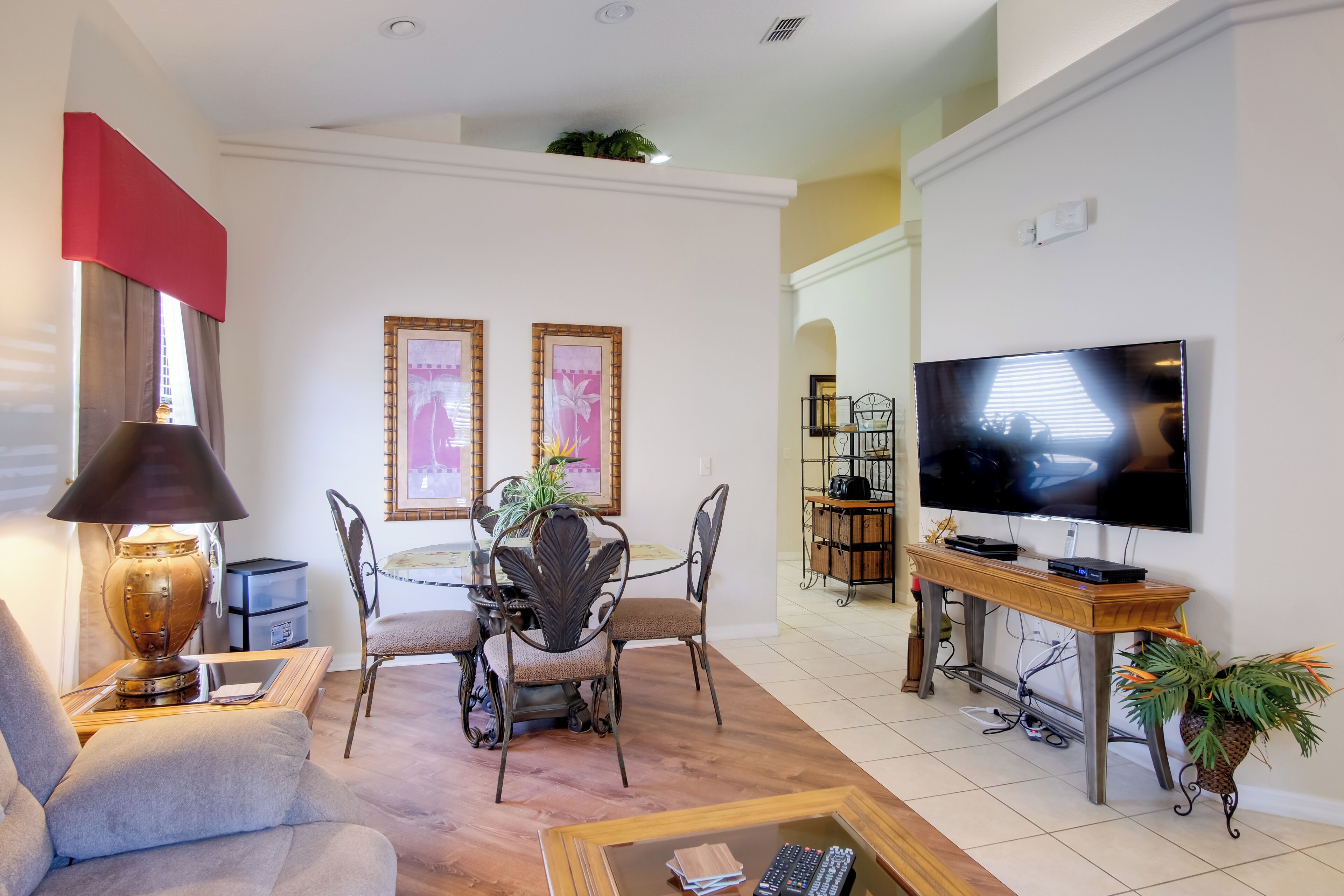 A living room with a sofa, a dining table with chairs, a TV, and a coffee table.