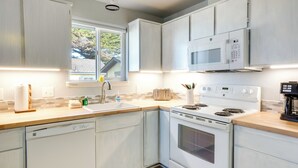 A modern kitchen with white cabinets, a built-in microwave, a stove, and a dishwasher. - Bandon Beach House Rental: Walk to Downtown! (Bandon)