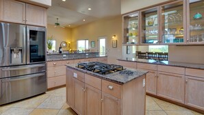 Una cucina moderna con elettrodomestici in acciaio inossidabile, mobili in legno e un'isola centrale.