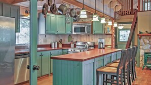 A kitchen with green cabinets, a wooden island, and a stove. - Waterfront Denmark Complex w/ Dock on 12 Acres! (Denmark)