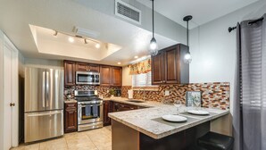 A modern kitchen with stainless steel appliances, a large island with bar stools, and a patterned backsplash. - Phoenix Home w/ Pool, Near Golf, Hiking & More! (Phoenix)