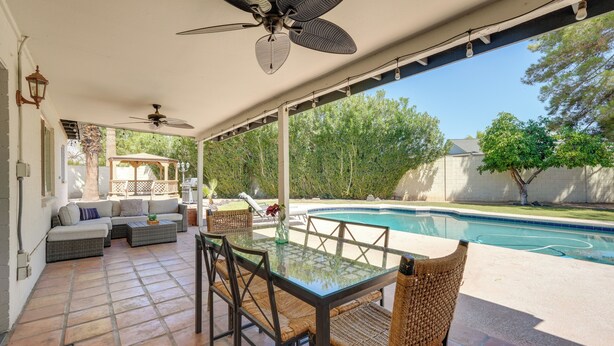 A covered patio with a pool, outdoor furniture, and a ceiling fan. - Phoenix Home w/ Pool, Near Golf, Hiking & More! (Phoenix)