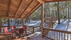 Eine Holzterrasse mit roten, gemusterten Stühlen und einer Treppe zu einer erhöhten Ebene.