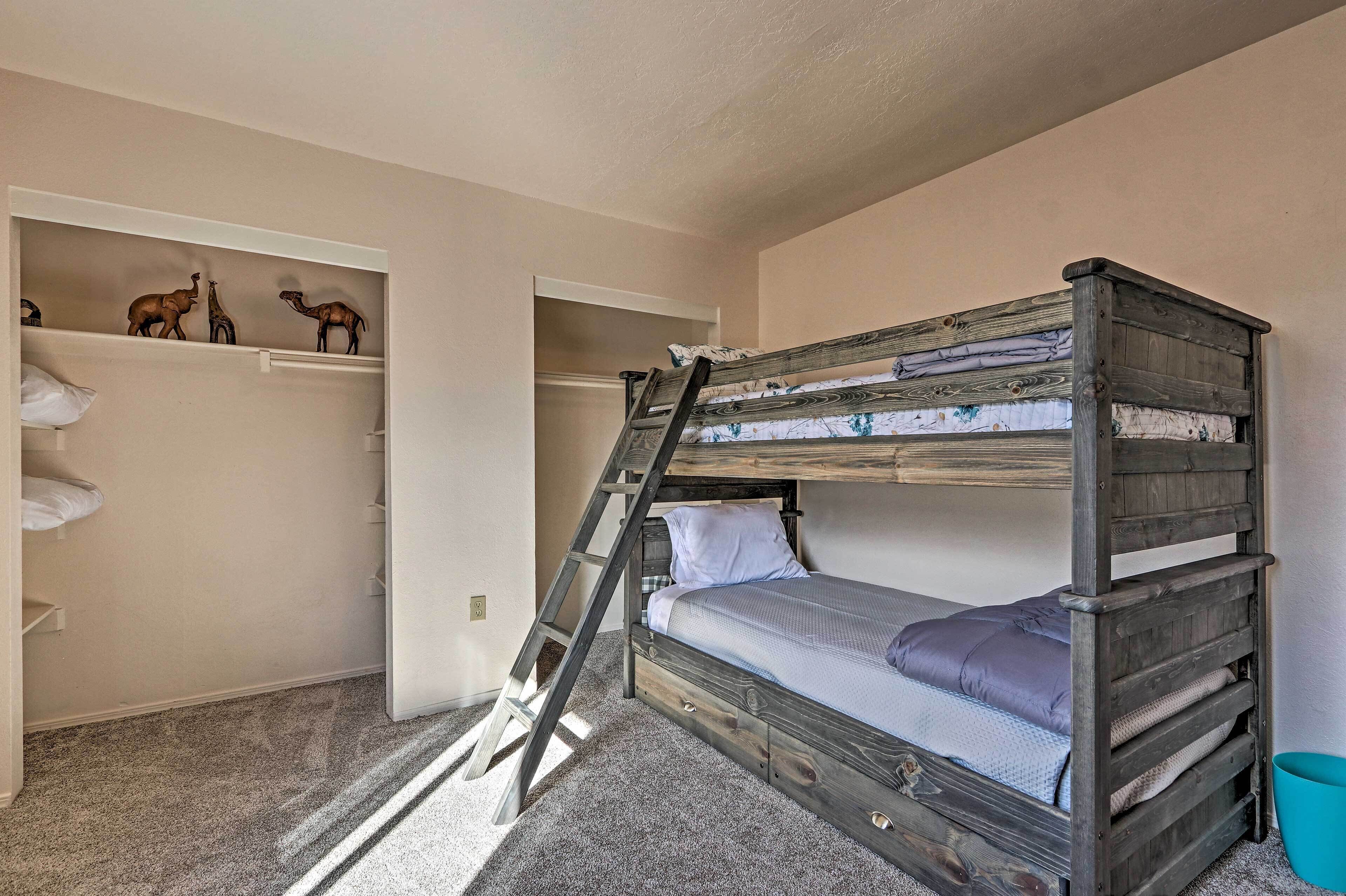 A bunk bed with a ladder, a shelf with animal figurines, and a small blue bucket.