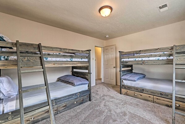 A room with two bunk beds, a door, and a ceiling light fixture.
