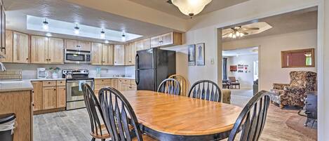 A spacious kitchen with wooden cabinets, a dining table with chairs, and a central island.