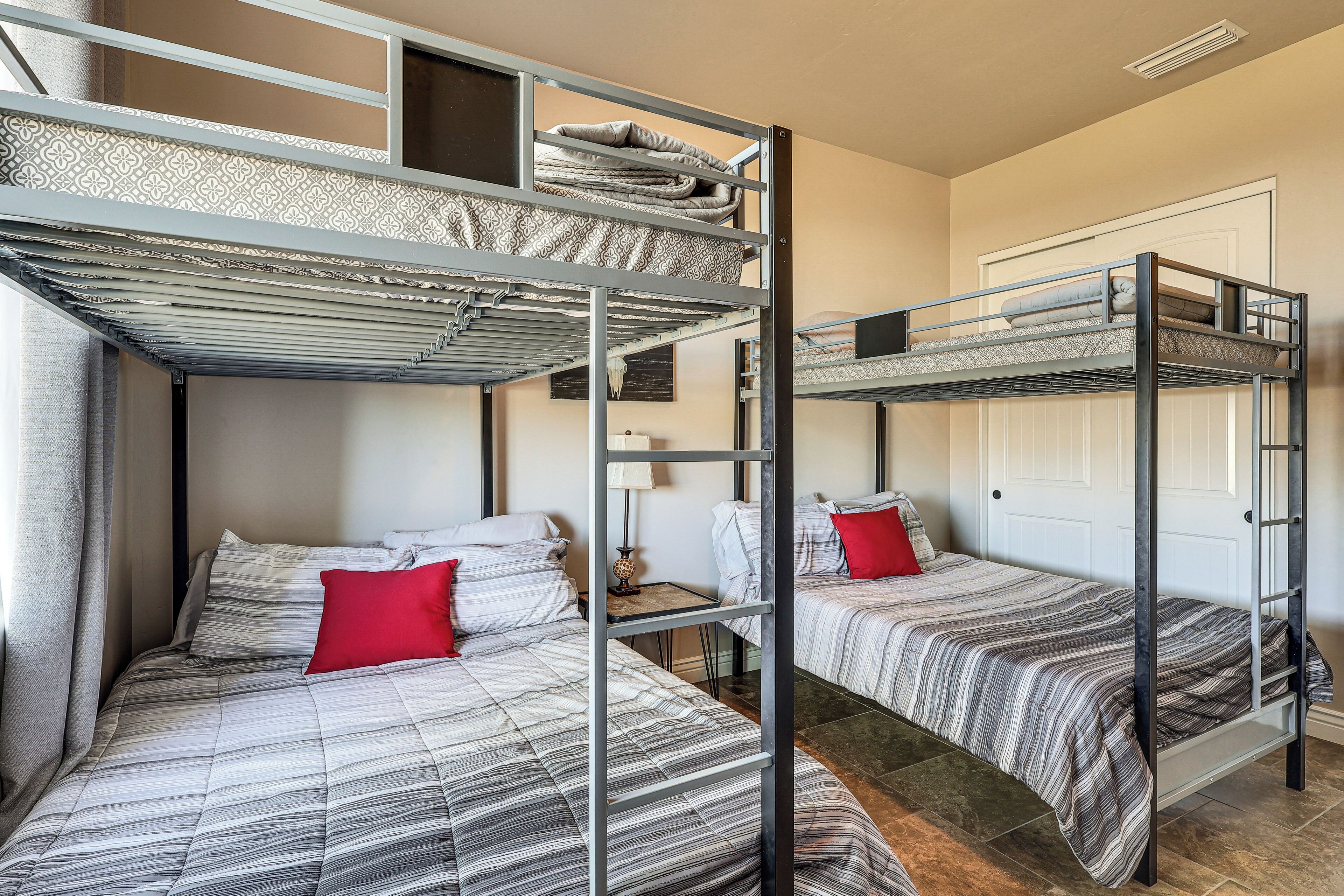A dormitory room with bunk beds, a small table, and a door.