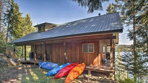 A wooden cabin with a metal roof, a porch, and kayaks. - Swim, Boat & Explore! South Lake Coeur D'alene Gem (Worley)