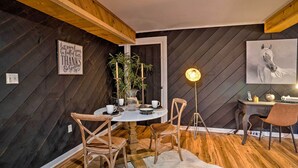 A cozy dining area with a round table, wooden chairs, a potted plant, and a framed quote on the wall. - Country-chic Waxhaw Studio w/ Pool Access! (Waxhaw)