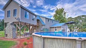 A two-story house with a backyard pool, a stone structure, and outdoor furniture. - Country-chic Waxhaw Studio w/ Pool Access! (Waxhaw)