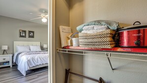 A bedroom with a bed, nightstand, and a shelf with a Crock-Pot and other items. - Close to Golfing & Shopping: Condo in Scottsdale! (Scottsdale)