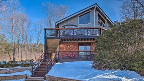 A modern two-story house with a wooden deck and a staircase leading to a balcony. - Pet-friendly Gilford Home by Gunstock Ski Mountain (Gilford)
