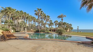 A pool area with lounge chairs, palm trees, and a view of the ocean. - Beachfront Rocky Point Villa w/ Ocean Views! (Puerto Peñasco)