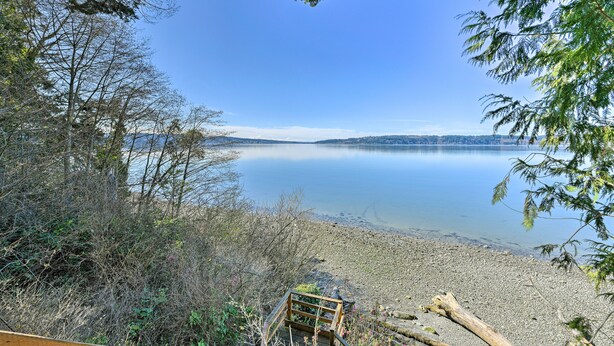 A lakeside view with a wooden deck and a bench. - Cozy Beachouse: View & Deck, Steps From Skagit Bay (La Conner)