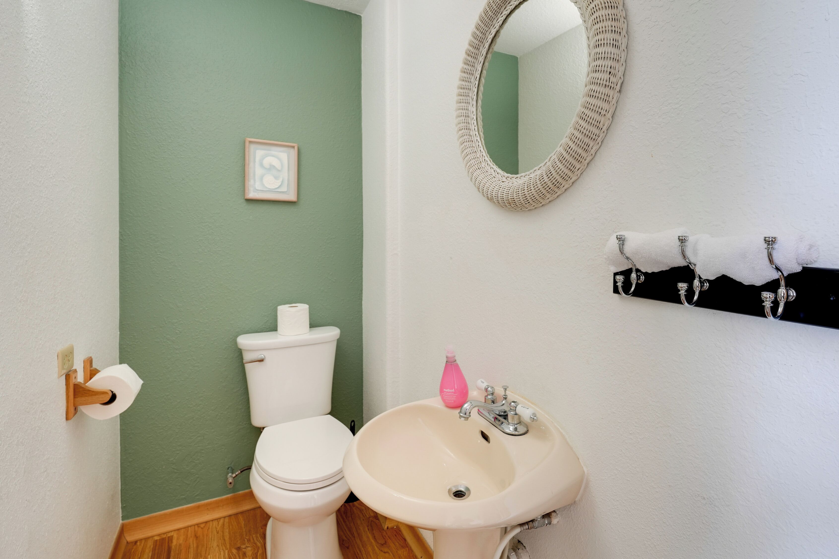 A bathroom with a toilet, sink, and mirror.