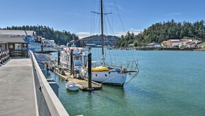 A waterfront marina with boats docked, a pier, and buildings in the background. - Cozy Beachouse: View & Deck, Steps From Skagit Bay (La Conner)