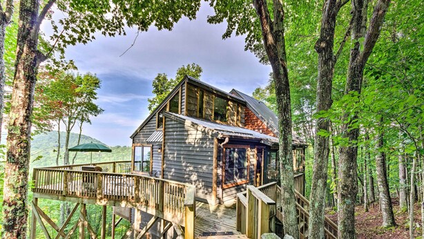 A wooden cabin with a deck, surrounded by trees. - 3 Mi to Beech Mtn: Treetop Cabin w/ Deck & Views (Banner Elk)