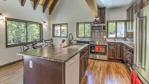A spacious kitchen with wooden beams, large windows, and modern appliances. - Cozy Dumont Cottage With Mill Creek Views! (Dumont)