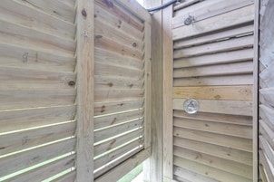 Una valla de madera con listones horizontales y un pestillo de metal.