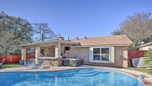 Un jardin avec une piscine, un jacuzzi et un patio couvert.