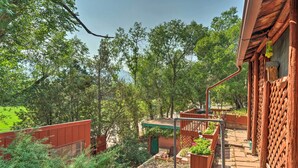 A wooden cabin with a balcony overlooking a garden and forest. - Colorful Bungalow By Pikes Peak/garden of the Gods (Manitou Springs)