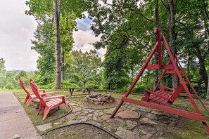 Un parc avec des balançoires en bois rouge, des allées pavées et un foyer.