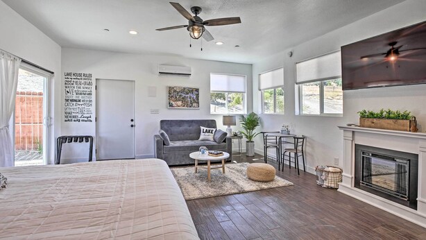 A spacious living room with a fireplace, a ceiling fan, and a large TV. - Cottage by the Lakes w/ Patio by Lake Nacimiento (Bradley)