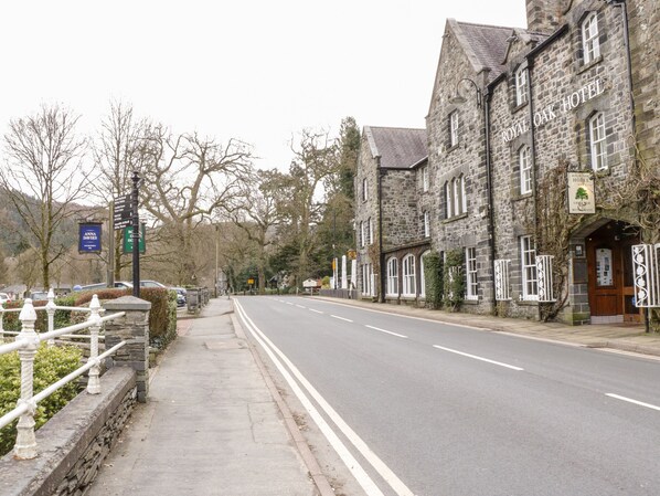 Un edificio de piedra con un letrero del Hotel Royal Oak y un letrero cercano para Anna Davies.