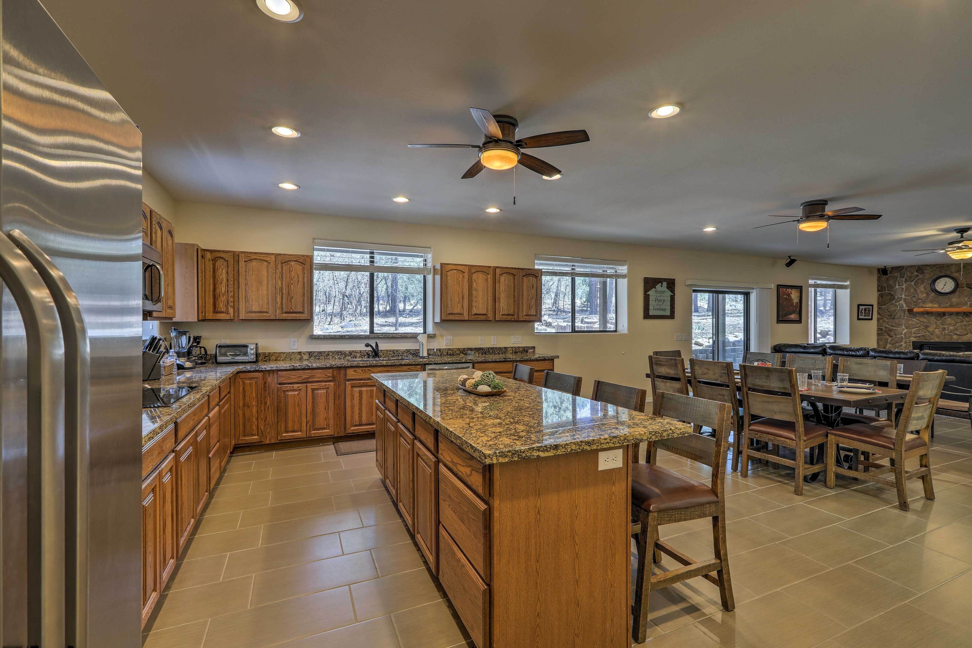 A spacious kitchen with wooden cabinets, granite countertops, and a central island with seating.