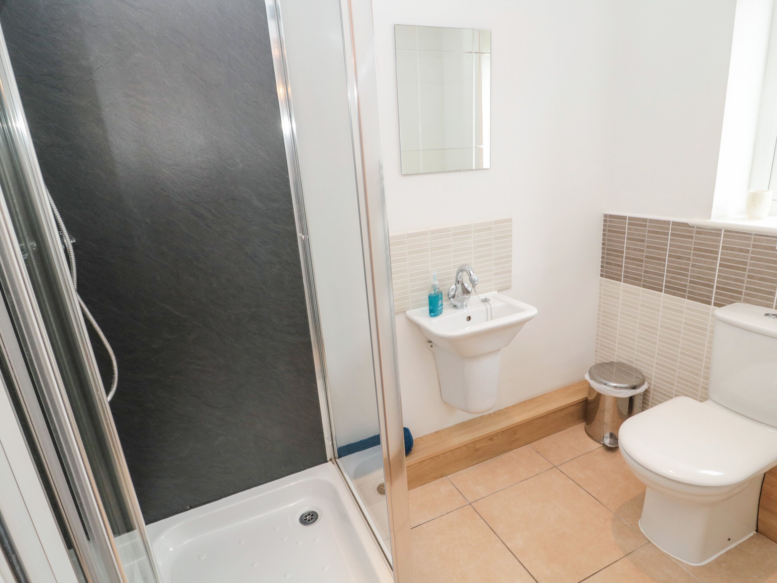 Un baño con ducha, lavamanos e inodoro.