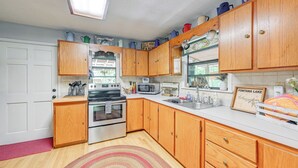 A kitchen with wooden cabinets, stainless steel appliances, a microwave, and a sink.