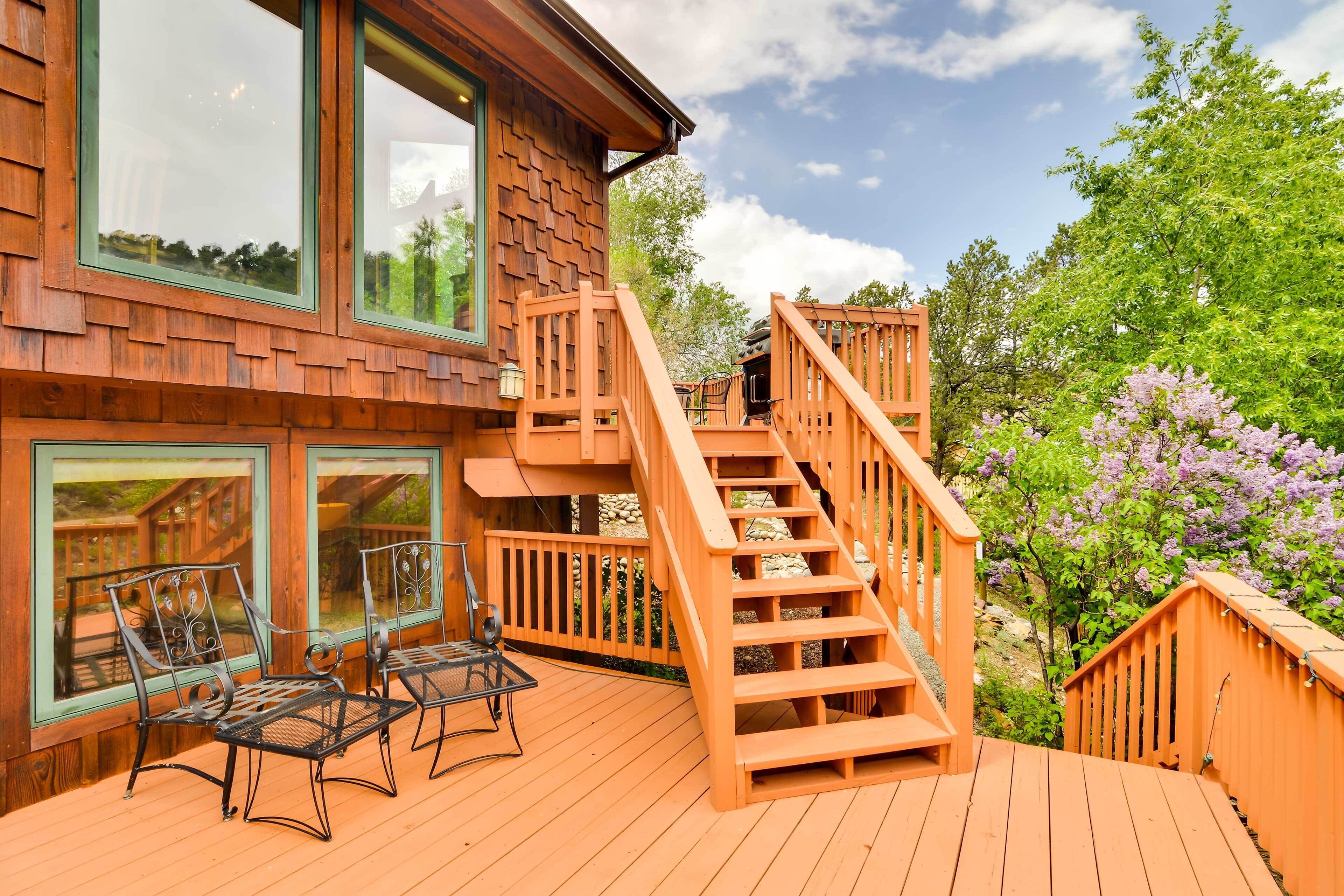 A wooden deck with outdoor furniture and a staircase leading to a deck area.