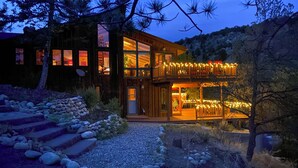 Un bâtiment moderne à deux étages, doté d’une entrée bien éclairée et d’un balcon agrémenté de guirlandes lumineuses.