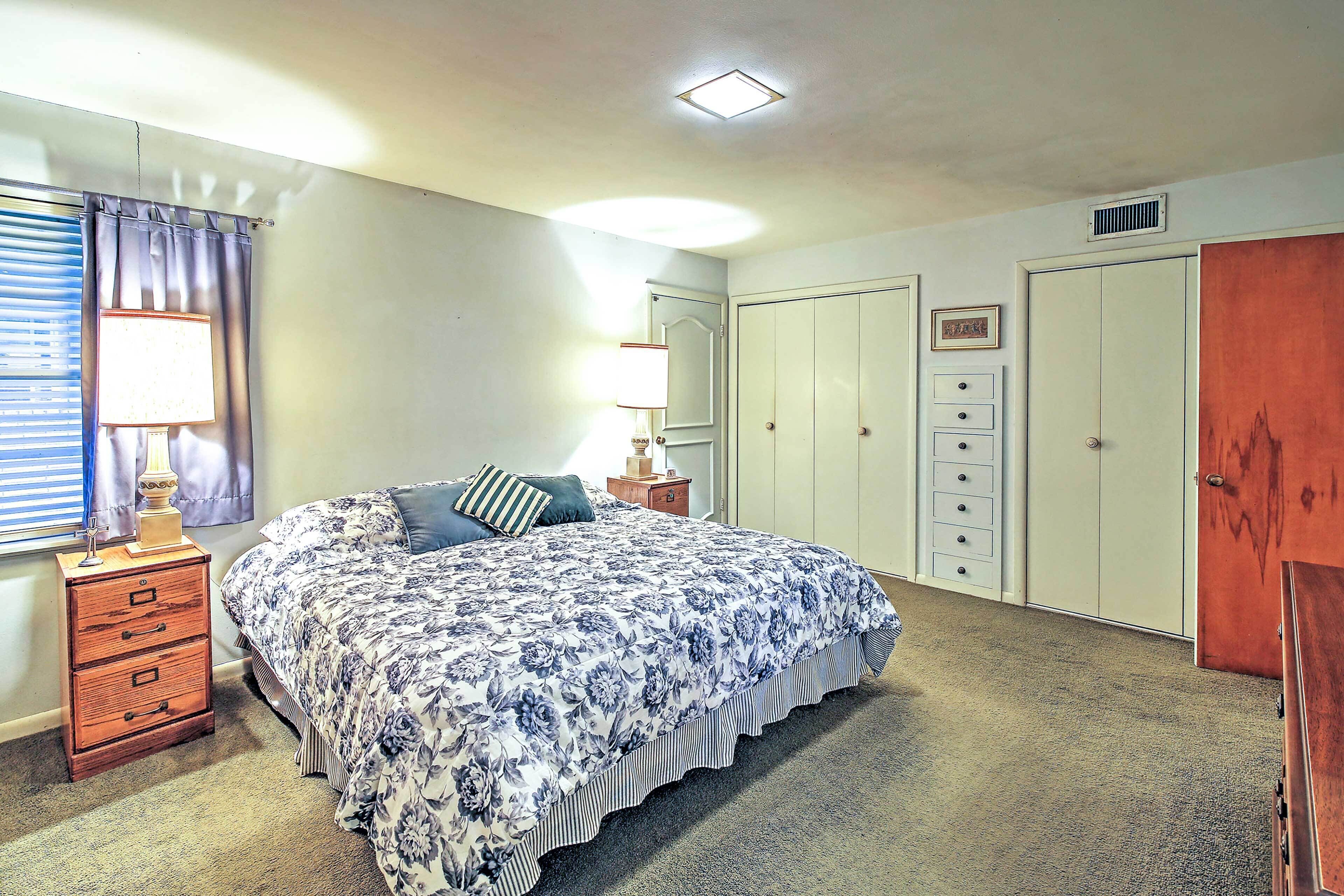 A bedroom with a bed, dresser, nightstand, and wardrobe.