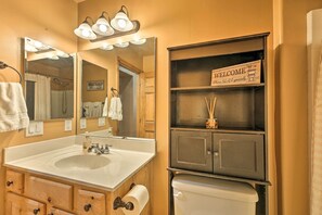 A bathroom with a sink, mirror, vanity, and a welcome sign. - 3 Mi to Fool Hollow Lake: Cozy Cabin w/ Deck (Show Low)