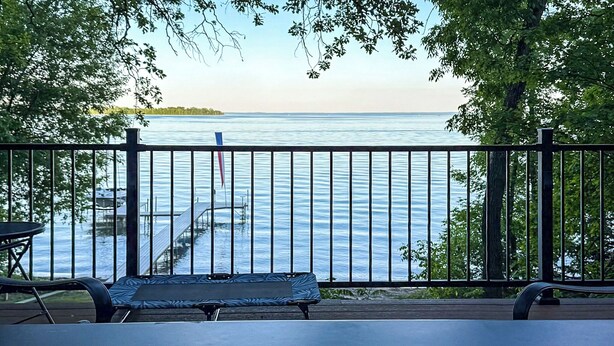 Une terrasse avec vue sur un lac, une table et un banc.