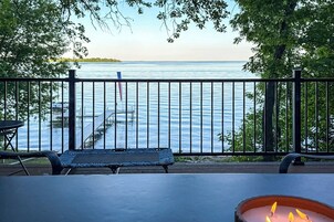 Una terraza con vista a un lago, una mesa y un banco.