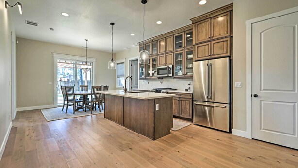 A spacious kitchen with wooden cabinets, stainless steel appliances, and pendant lighting. - Flagstaff Oasis w/ Hot Tub - 3 Mi to Downtown! (Flagstaff)