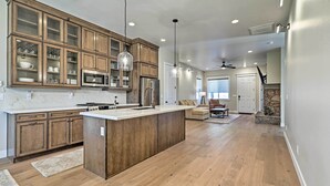 A spacious kitchen with wooden cabinets, a central island, and a dining area with a sofa and table. - Flagstaff Oasis w/ Hot Tub - 3 Mi to Downtown! (Flagstaff)