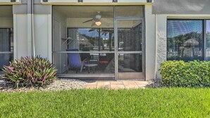 A modern building with a glass door entrance, a balcony with outdoor furniture, and a small garden area with plants. - Sweet Snowbird Escape ~ 2 Mi to St Pete Beach (St. Petersburg)