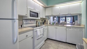 A modern kitchen with white cabinets, a microwave, an oven, and a dishwasher. - Sweet Snowbird Escape ~ 2 Mi to St Pete Beach (St. Petersburg)