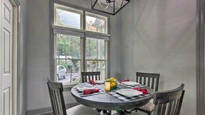 A dining area with a round table, four chairs, and a window with blinds. - Surrounding Mtn Views! Modern Smokies Retreat (Burnsville)