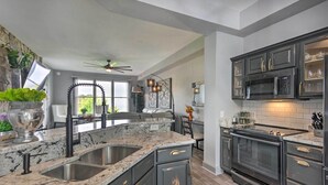 A modern kitchen with granite countertops, stainless steel sinks, and dark cabinetry. - Surrounding Mtn Views! Modern Smokies Retreat (Burnsville)