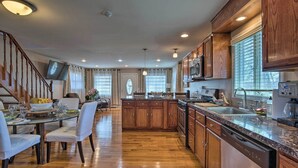 Una cocina amplia con armarios de madera, encimera de granito y lavavajillas.